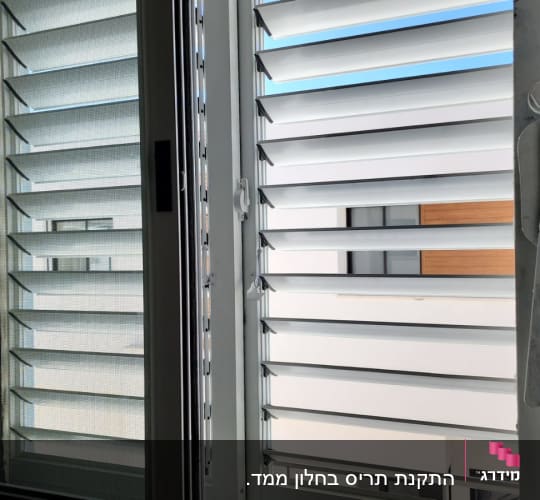 תריסי אלומיניום פתוחים בחלון זכוכית